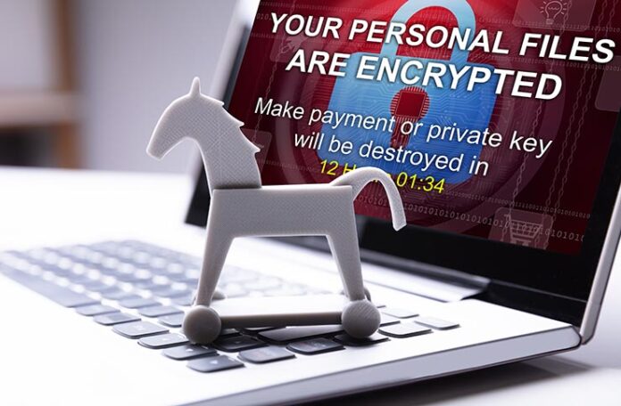 trojan horse in front of laptop screen with message your personal files are encrypted