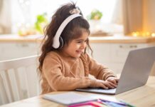 Young girl with headphones using laptop