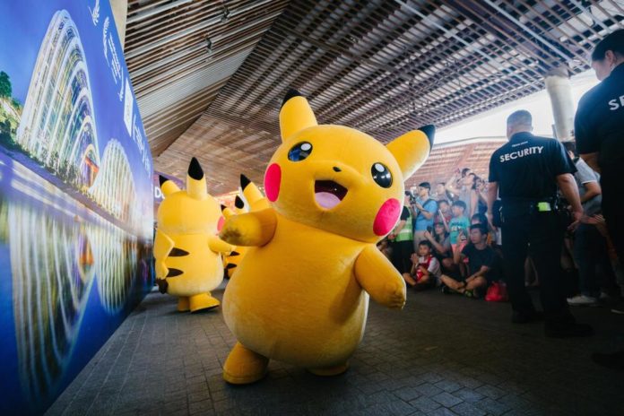 People at an anime convention looking at pikachu