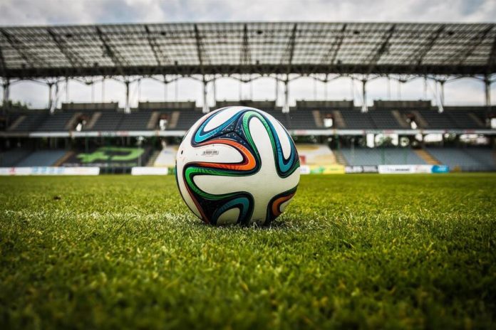 Up close of a soccer ball on the grass of a stadium