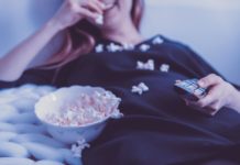 Woman on a couch eating popcorn
