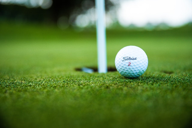 Close-up of a Titleist golf ball on the green next to the pin at the Masters Tournament