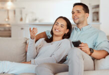 Young couple relaxing on the couch while streaming the latest movies