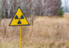 A nuclear radiation warning sign outdoors in a grassy field