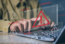 Why Aren’t Illegal Streaming Services Shut Down More Often? Warning signs scattered around an image of a man's hands on a computer.