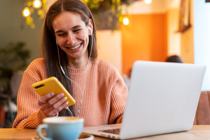 A woman smiling while checking her smartphone