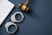 Fines, Lawsuits, and Jail Time: What Happens if You Get Caught Watching Illegal Sports Streams? A computer keyboard with handcuffs and a judge’s gavel.