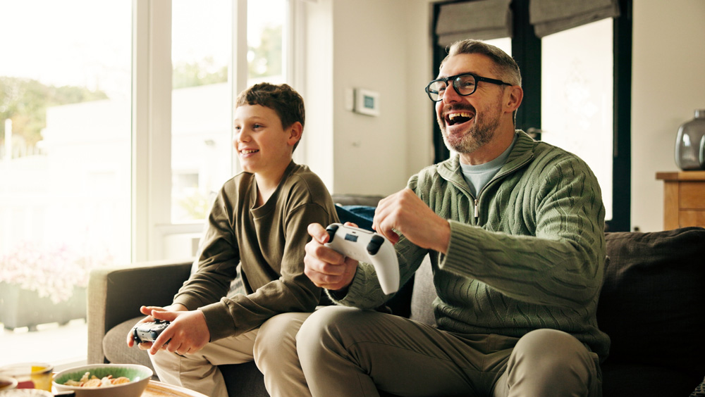 Summer_Gaming2 Father, child and play video game with celebration, win competition and parent with son in home. Happy kid, dad and success with console with fist pump, happiness and bonding together with family