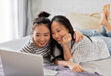 Soap2Day Is Gone — Here’s Where to Watch Those Movies & Shows Legally Two smiling women enjoying time together using a laptop in a cozy bedroom setting.